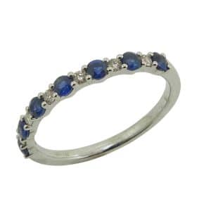 14K White gold alternating blue sapphire and diamond band claw set with six round brilliant cut diamonds, 0.08 total carat weight, and seven blue sapphires, 0.46 total carat weight.