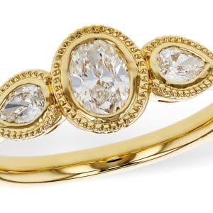 14K Yellow gold lady's ring with milgrain details bezel set with a 0.38 carat oval brilliant cut natural diamond and two pear brilliant cut natural diamonds, 0.44 total carat weight, G/H, SI+.