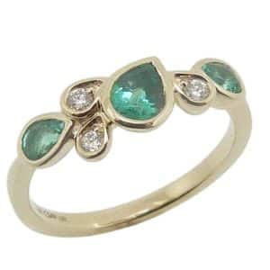14K Yellow gold lady's band bezel set with three round brilliant cut natural diamonds, 0.08 total carat weight, G/H, SI and three pear shape emeralds, 0.54 total carat weight.