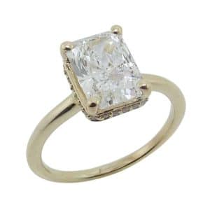 14K Yellow gold hidden halo solitaire engagement ring claw set in the centre with a 2.04 carat, D, VVS2 radiant brilliant cut lab grown diamond and accented in the hidden halo with twenty-six claw set round brilliant cut lab grown diamonds, 0.104cttw, F/G, VS.