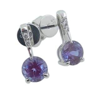 14K White gold drop earrings claw set with 5mm round Chatham Alexandrites, 1.26 total carat weight, and round brilliant cut lab grown diamonds, 0.03 total carat weight.