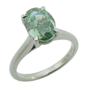 14K White gold solitaire hidden halo engagement ring claw set with a 2.05 carat fancy vivid green, VS1, oval lab grown diamond accented in the hidden halo with eightteen natural round brilliant cut diamonds, 0.07cttw, G/H, SI.