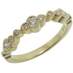 14K Yellow gold scalloped edge lady's band with milgrain detail claw set with thirteen round brilliant cut diamonds, 0.24cttw.