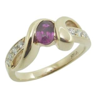 14K Yellow gold lady's ring semi-bezel set with a 0.497 carat oval ruby and accented with eight natural round brilliant cut diamonds, 0.158cttw.