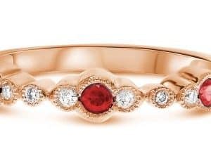 14K Rose gold lady's ring with milgrain detail bezel set with three ruby's, 0.20 total carat weight, and ten round brilliant cut diamonds, 0.09 total carat weight.