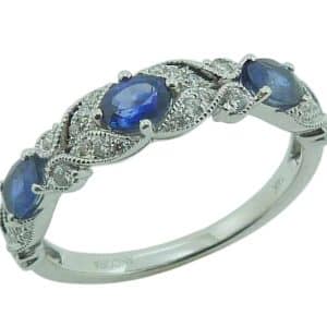 14K White gold lady's band with milgrain detail claw set with three oval blue sapphires, 0.63cttw, and thirty-two round brilliant cut diamonds, 0.20cttw.