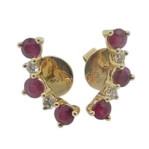 14K Yellow gold curved line studs claw set with six ruby's, 0.57 total carat weight, and four round brilliant cut diamonds, 0.09 total carat weight.