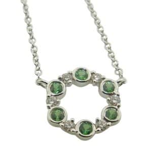 14K White gold open circle pendant necklace bezel set with six tsavorite garnets, 0.19 total carat weight, and claw set with six round brilliant cut diamonds, 0.10 total carat weight.