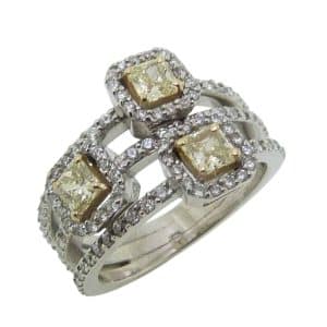 Estate item - 14K White and yellow gold lady's diamond dinner ring set with three fancy yellow radiant cut diamonds, 0.75cttw, and 102 round brilliant cut natural diamonds, 0.57cttw.