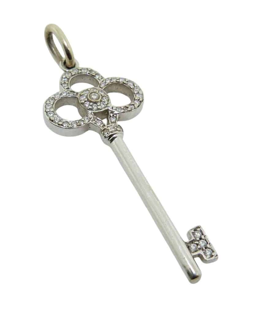 Estate 18K White gold Tiffany & Co key pendant set with round brilliant cut natural diamonds, 0.20 total carat weight, SI.