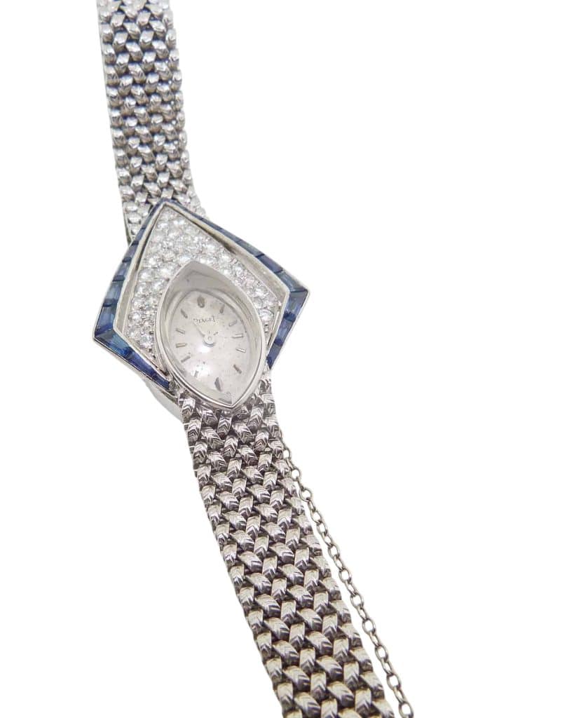 Estate item - 18K White gold Piaget lady's watch with a sapphire crystal accented with tapered baguette blue sapphires and forty full cut and single cut diamonds - note needs to be worn on a small wrist.