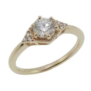 14K Yellow gold hexagonal milgrain accented engagement ring claw set in the centre with a 0.54 carat, D, VVS2 round billiant cut diamond lab grown diamond and accented with six claw set round brilliant cut lab grown diamonds, 0.045cttw.