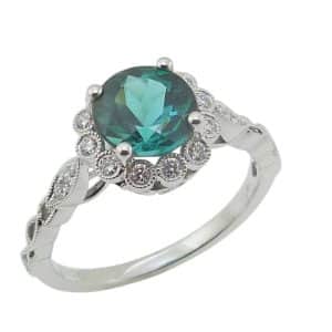 14K White gold halo lady's ring claw set in the centre with a 1.35 carat blue/green tourmaline (hard to find colour) accented with eighteen claw set round brilliant cut side diamonds totalling 0.18 carats, G/H, VS-SI.