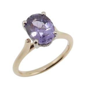 14K Yellow and white gold lady's cathedral shank ring set in the centre with a 2.08 carat purple oval spinel and set in the hidden halo with sixteen natural very good cut, round brilliant cut natural diamonds, 0.071 total carat weight, G/H, SI.