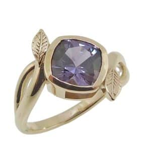 14K Yellow gold lady's bypass ring with leaf accents bezel set with a 1.52 carat purple spinel.