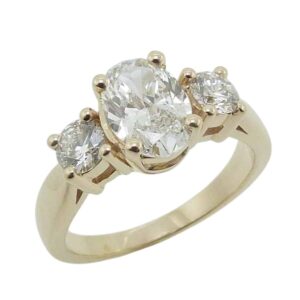 14K Yellow gold engagement ring claw set with a 1.32 carat, D, VVS2 oval brilliant cut lab grown diamond and accented with two round brilliant cut lab grown diamonds totaling 0.511 carats, E-F, VS+.