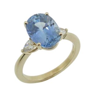 14K Yellow gold three stone engagement ring claw set in the centre with a 4.49 carat oval blue sapphire and two lab grown pear brilliant cut diamonds, 0.19 total carat weight, D-F, VVS-VS.