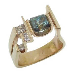 14K Yellow gold lady's ring channel set with 1.82 carat green/blue sapphire and accented with four natural princess cut diamonds totaling 0.287 carats, G/H, VS/SI.