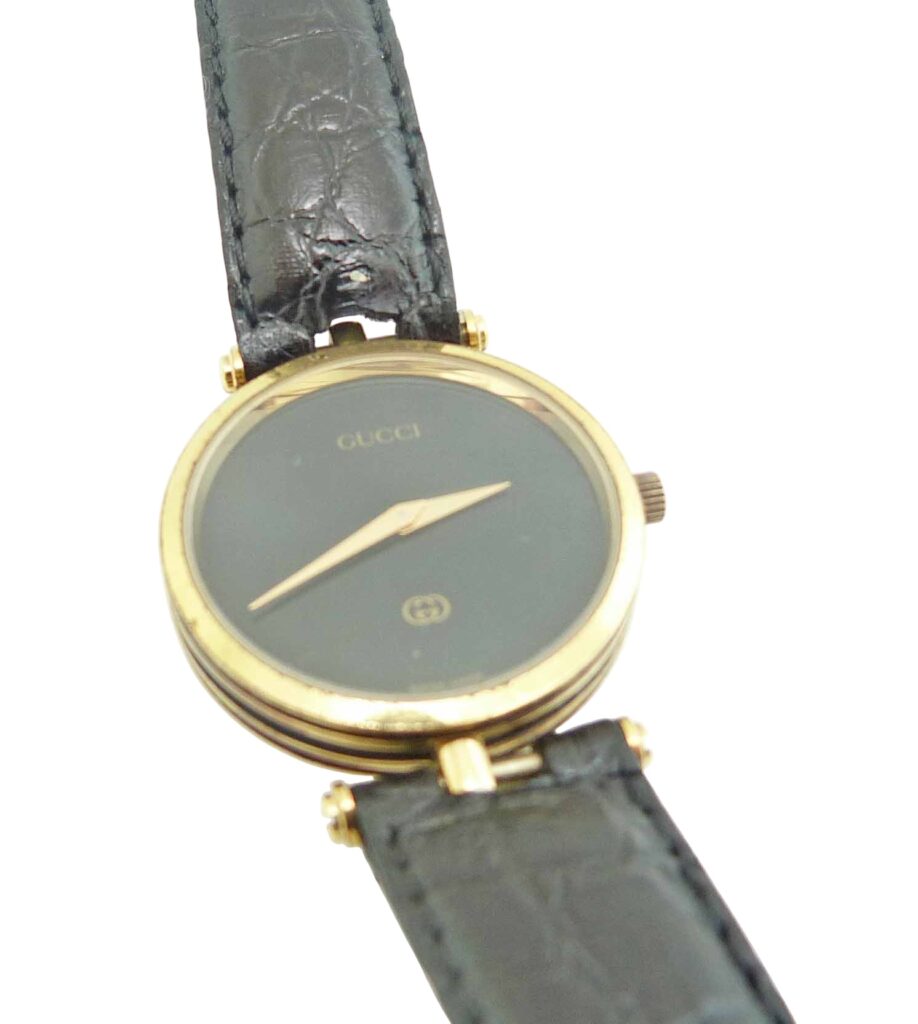Estate Lady's Gucci watch black dial gold plated round case with leather strap.